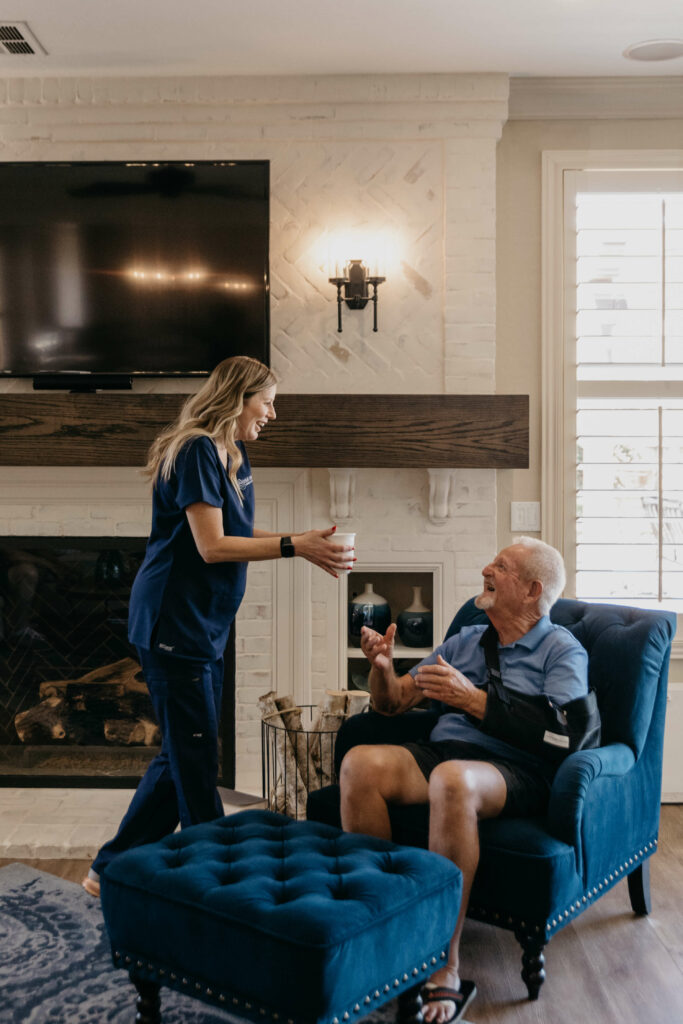 caregiver serving elderly man a cup of coffee