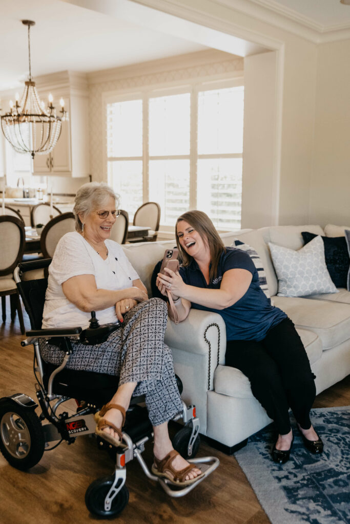 caregiver assisting elderly woman with cell phone