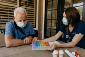 Nurse assisting elderly lman with medications