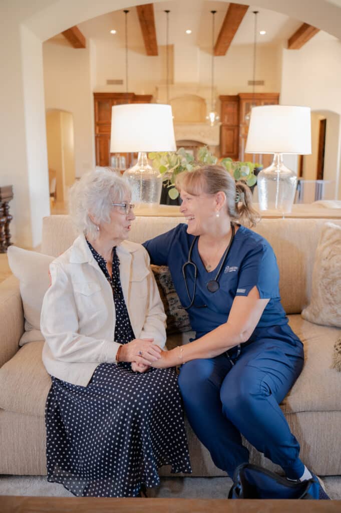 A caregiver and client enjoying a warm conversation, happy in each other’s company.