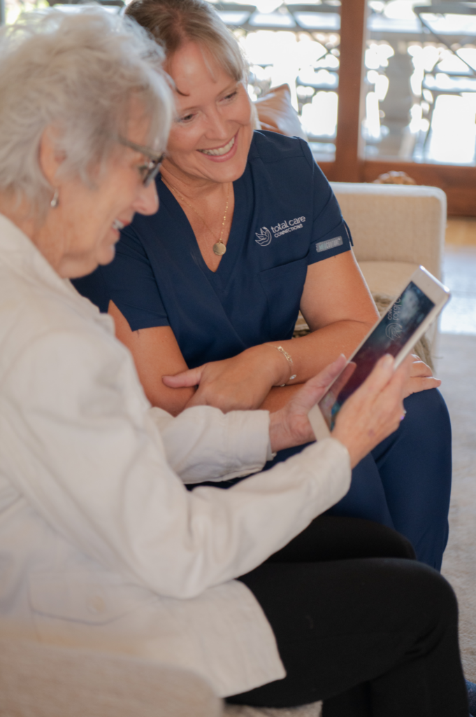 Caregiver and client using a tablet together, with focus on HIPAA-compliant and secure usage.